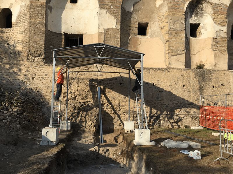 Un uomo è in piedi su una scala davanti a un edificio.