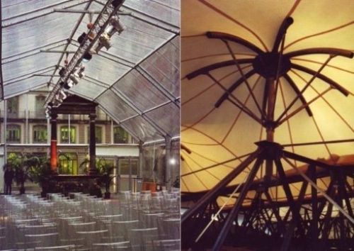 Una fila di sedie sotto un tetto trasparente accanto a un grande ombrellone