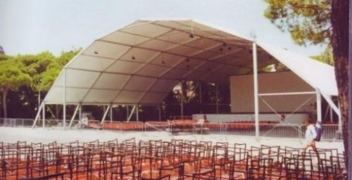 Una grande tenda bianca con file di sedie sotto