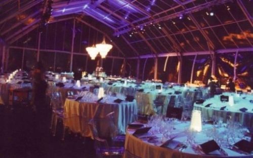 Una grande stanza con tavoli e sedie e luci viola