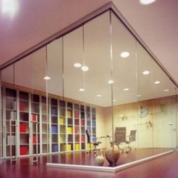 Una stanza con pareti di vetro e un orologio sul muro