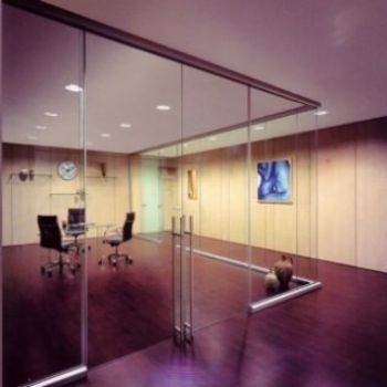 Una stanza con una parete di vetro e un orologio sul muro