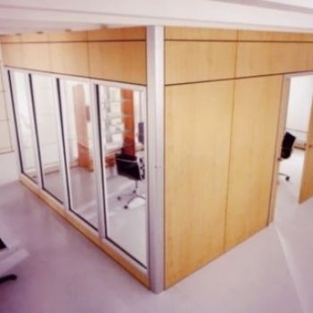 Una stanza con molte finestre e una sedia