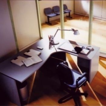 Una scrivania con una sedia e una lampada sopra