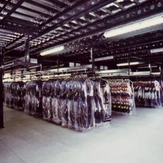 Un magazzino pieno di tanti vestiti avvolti nella plastica