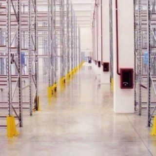 Un lungo corridoio in un magazzino con molti scaffali