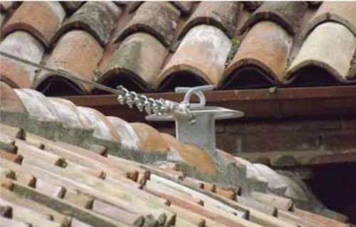 Un primo piano di un tetto con tegole e un filo collegato ad esso.