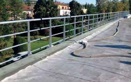 Una ringhiera metallica è posta sopra un tetto di cemento.