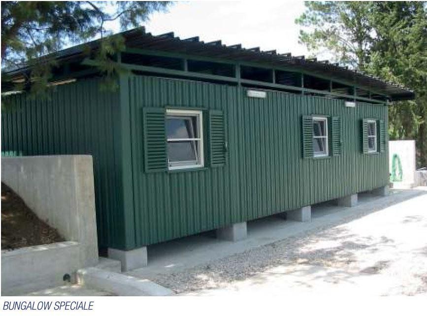 Una foto di un edificio verde con persiane alle finestre