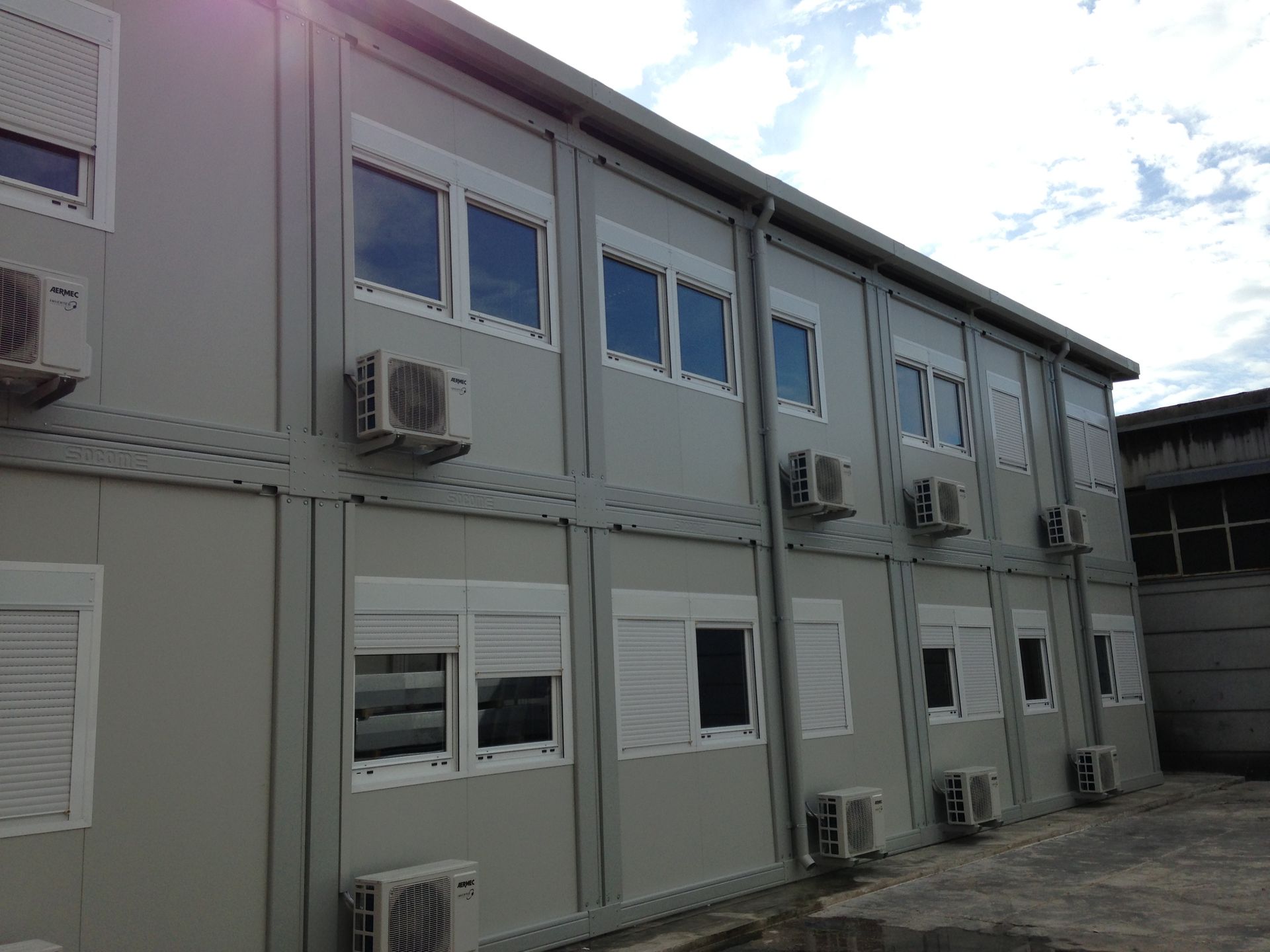 Un grande edificio con molte finestre e condizionatori sui lati.