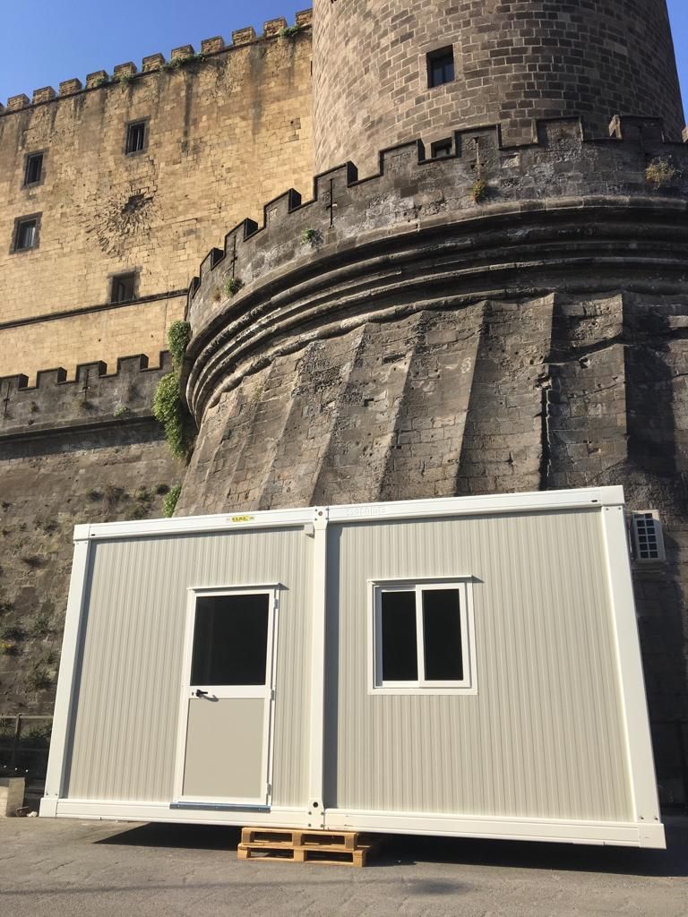 Un piccolo edificio si trova di fronte a un castello.