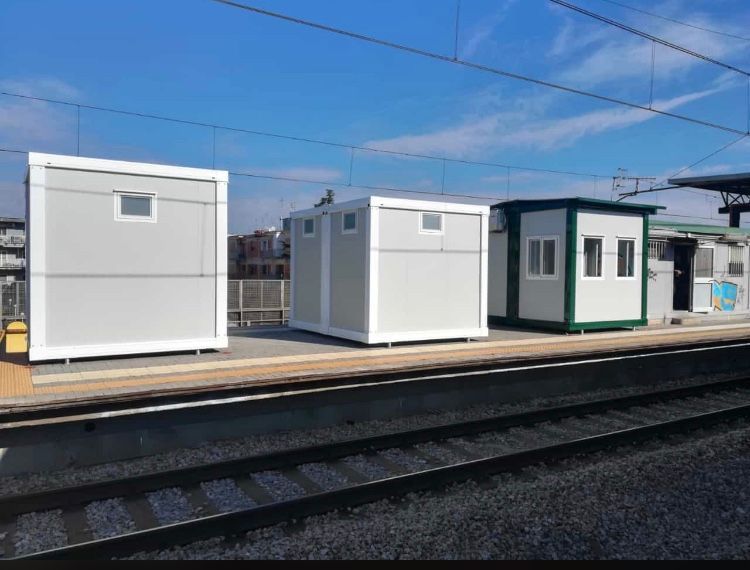 Una fila di edifici bianchi è seduta su una banchina del treno.