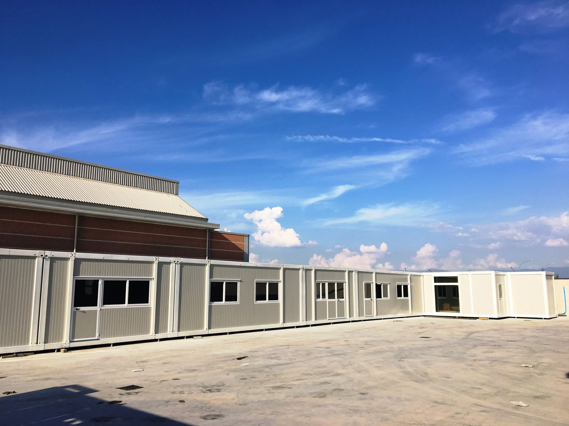 Davanti a un edificio è allineata una fila di container.