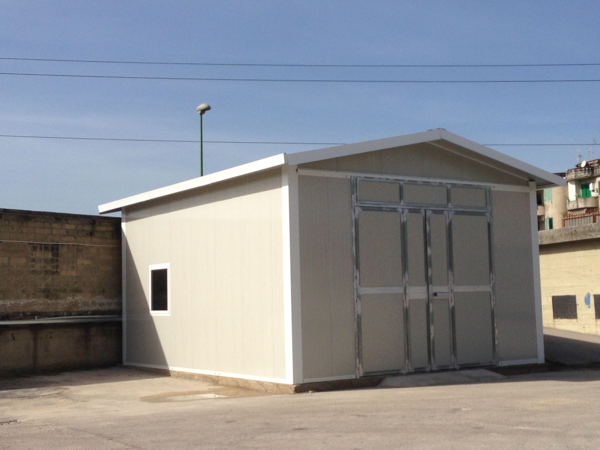 In un parcheggio si trova un edificio bianco con una grande porta del garage.