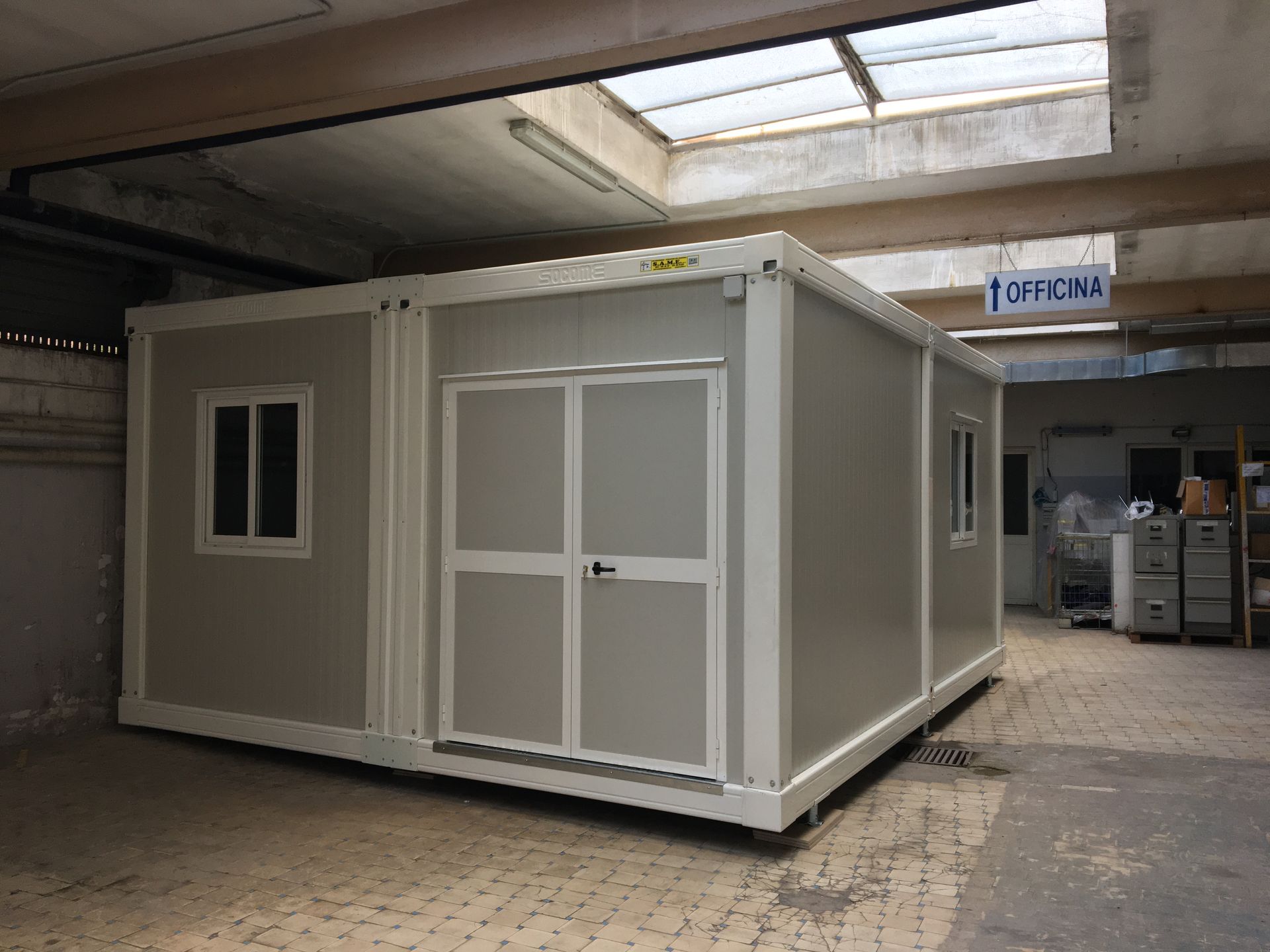 Un grande edificio bianco con sopra un cartello che dice oficina