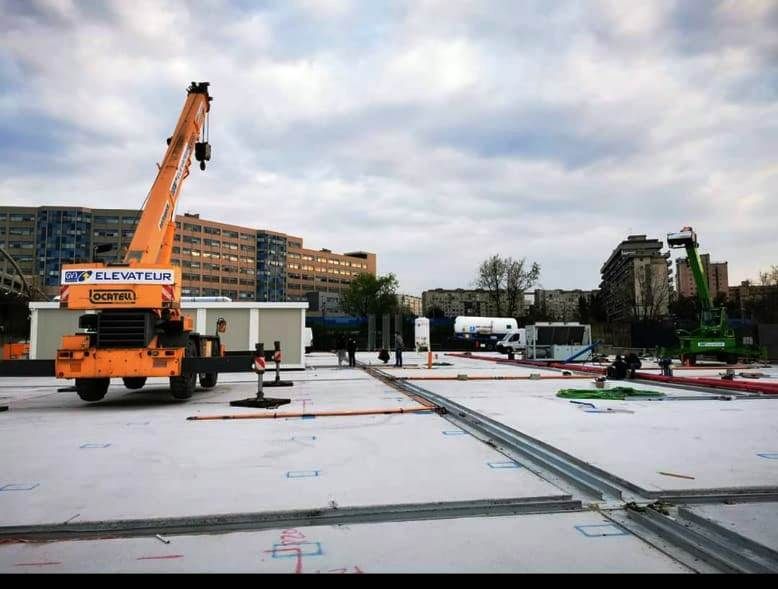 Una grande gru gialla è parcheggiata in un cantiere edile