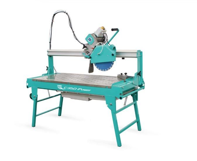 Una sega da tavolo turchese è seduta su una superficie bianca.