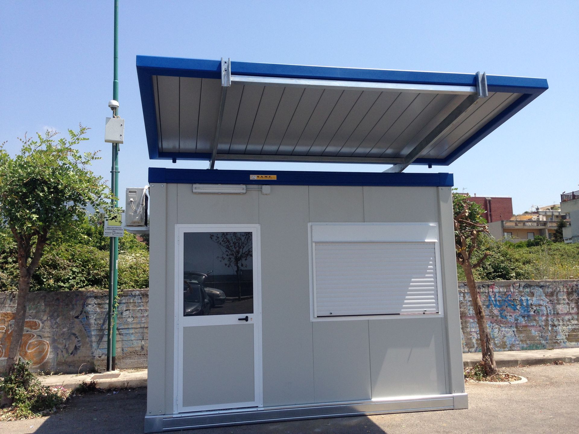 Un piccolo edificio con il tetto blu e una finestra