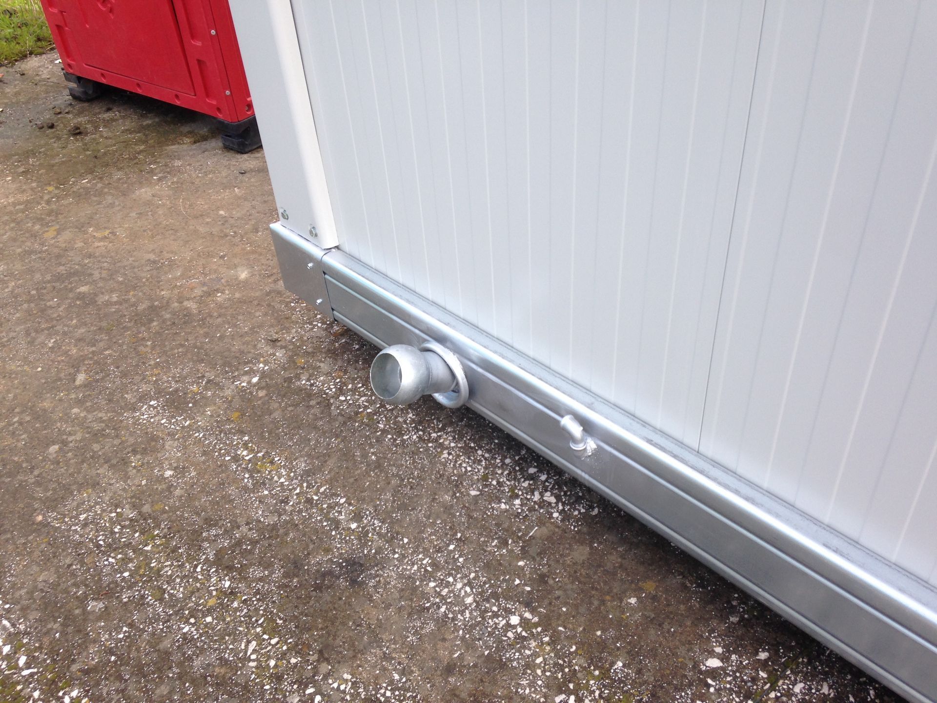 Un edificio bianco a cui è collegato un tubo di metallo.