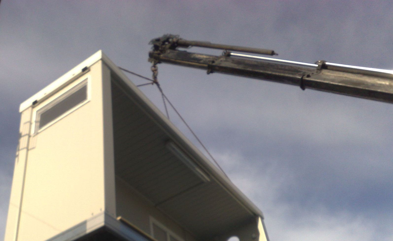 Una gru solleva un edificio in aria