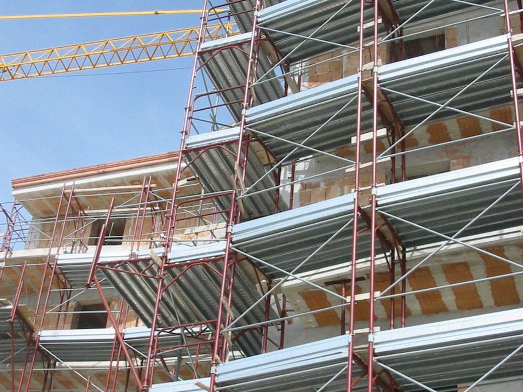 Un edificio in costruzione con impalcature e una gru sullo sfondo