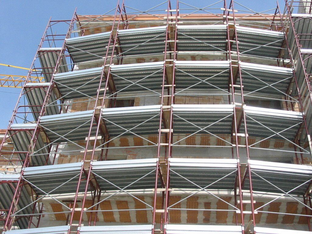 Un edificio in costruzione con impalcature e una gru sullo sfondo