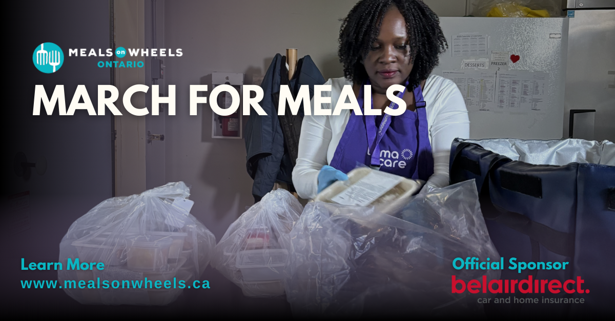 A woman in a purple apron is holding a bag of food.