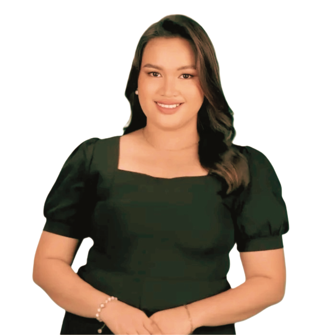 A person with long brown hair, wearing a black square-neck top, smiling while posing against a white background.