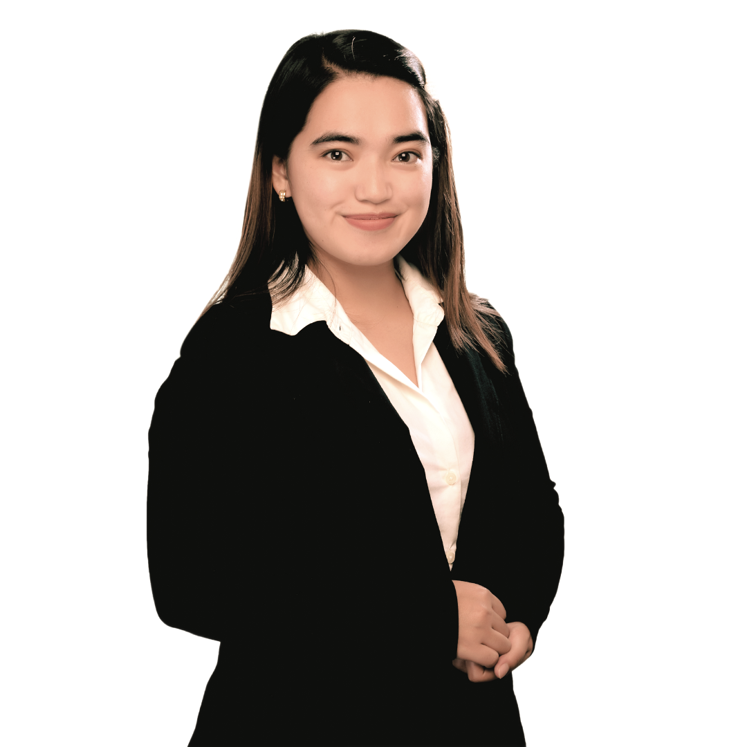 A person with long, dark hair wearing a black blazer over a white collared shirt, posing against a white background.