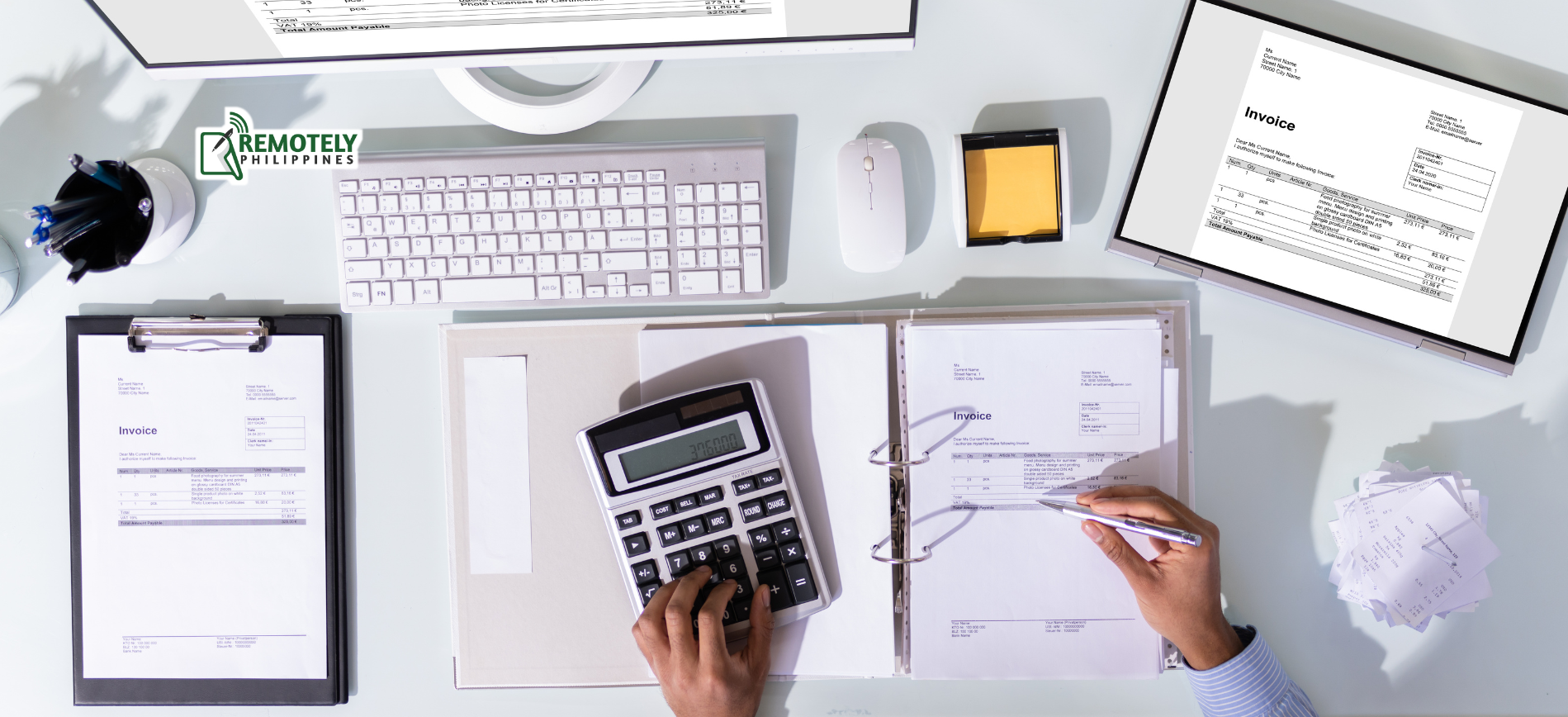 Overhead view of a person using a calculator and reviewing documents on a desk with a computer and office supplies.