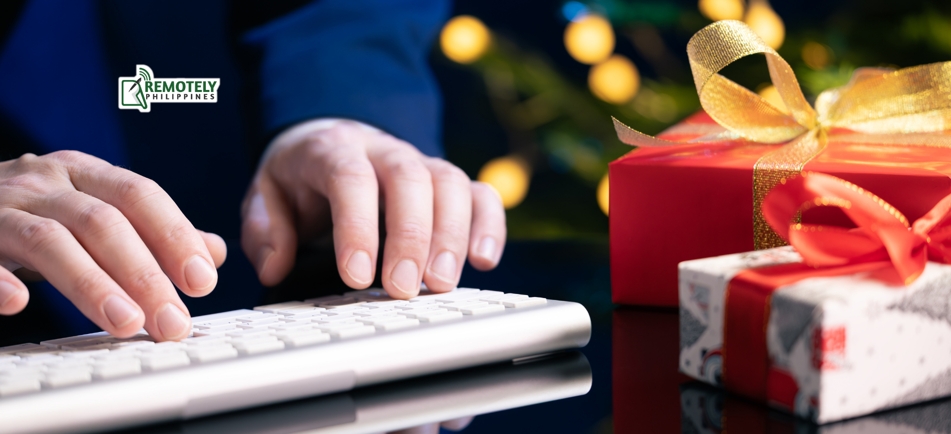 Hands typing on a keyboard next to wrapped gifts with bows in a festive setting.