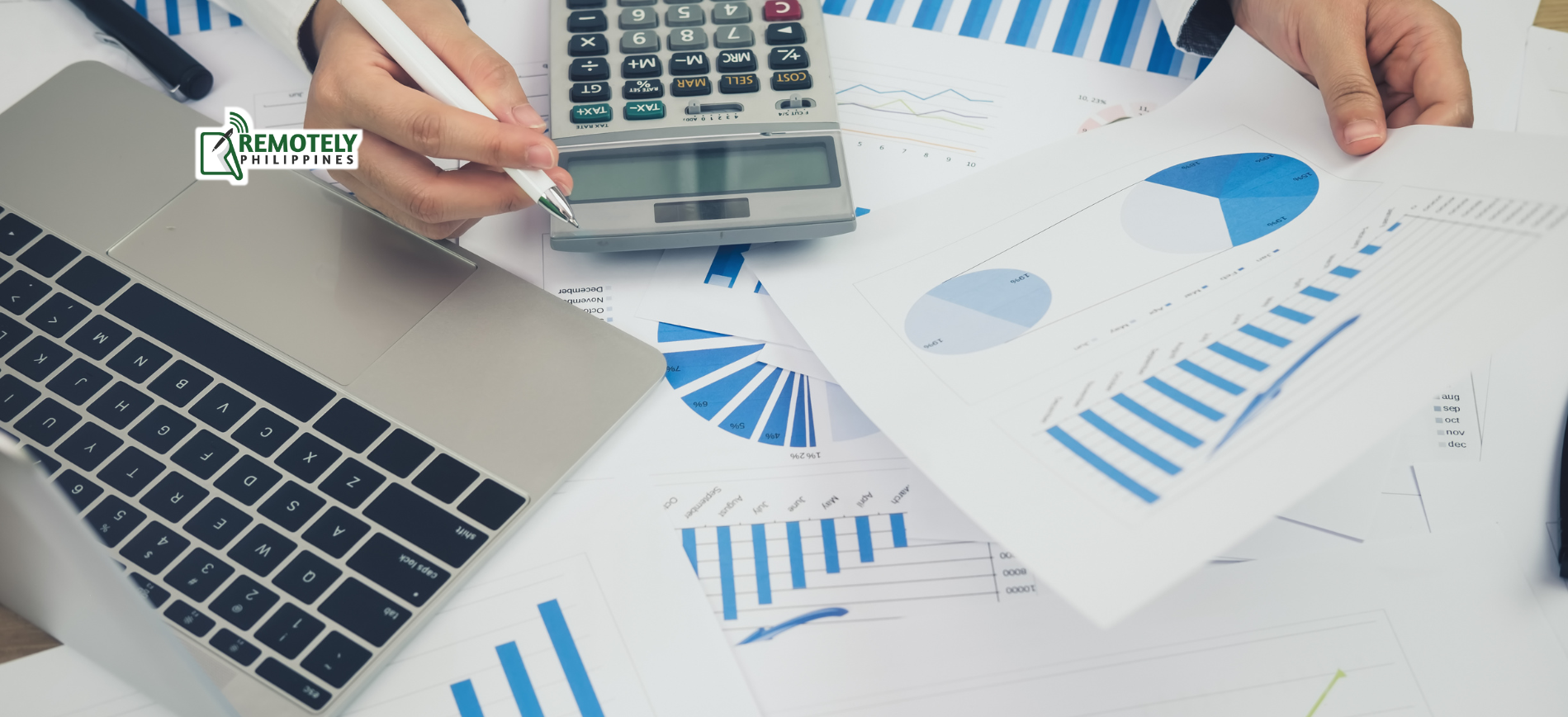 Person reviews financial data with a calculator and laptop, analyzing charts and graphs.