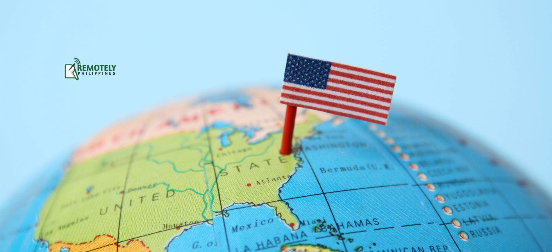 A small American flag is pinned to the top of a globe.