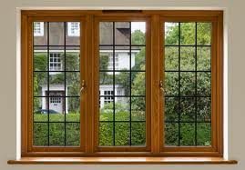 Wooden-framed window with green garden and house visible outside
