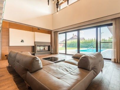 Modern living room with leather sectional and floor-to-ceiling windows overlooking a pool and yard