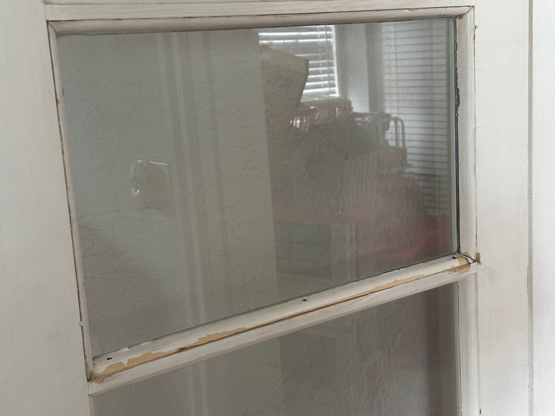 Window with frosted glass and a lower pane showing a faint indoor reflection