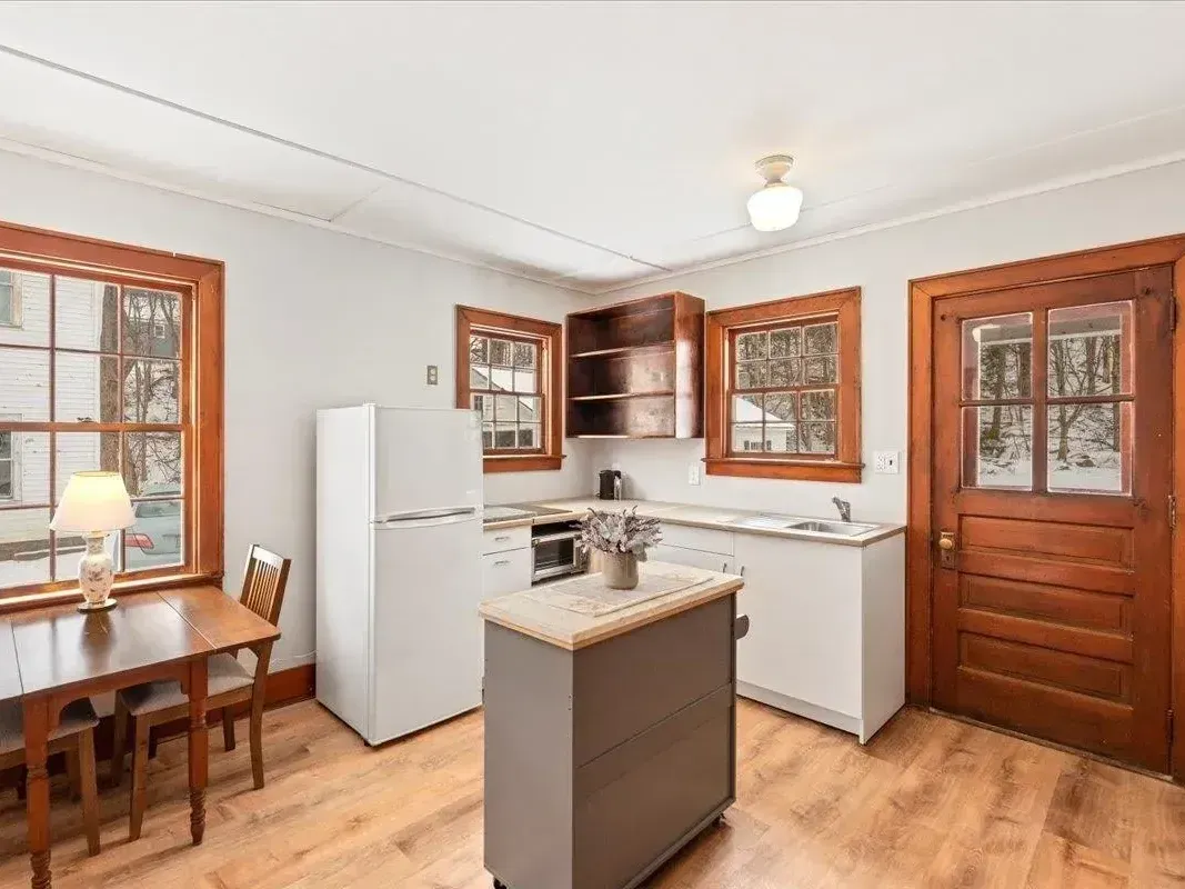 A newly renovated kitchen with fresh white walls and crisp wood trim by JG Services