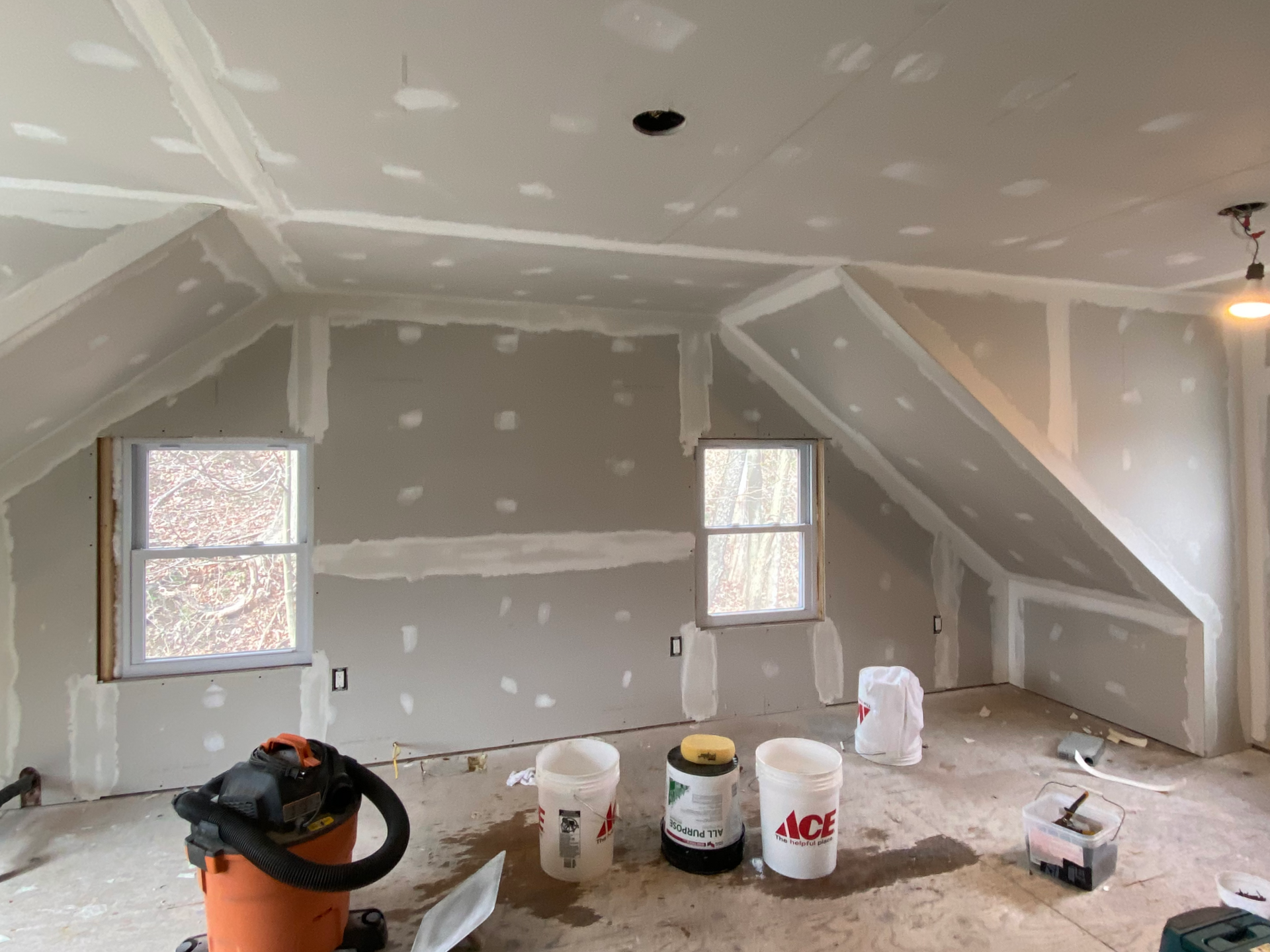 A room being renovated by JG Services with fresh drywall and drywall mud.
