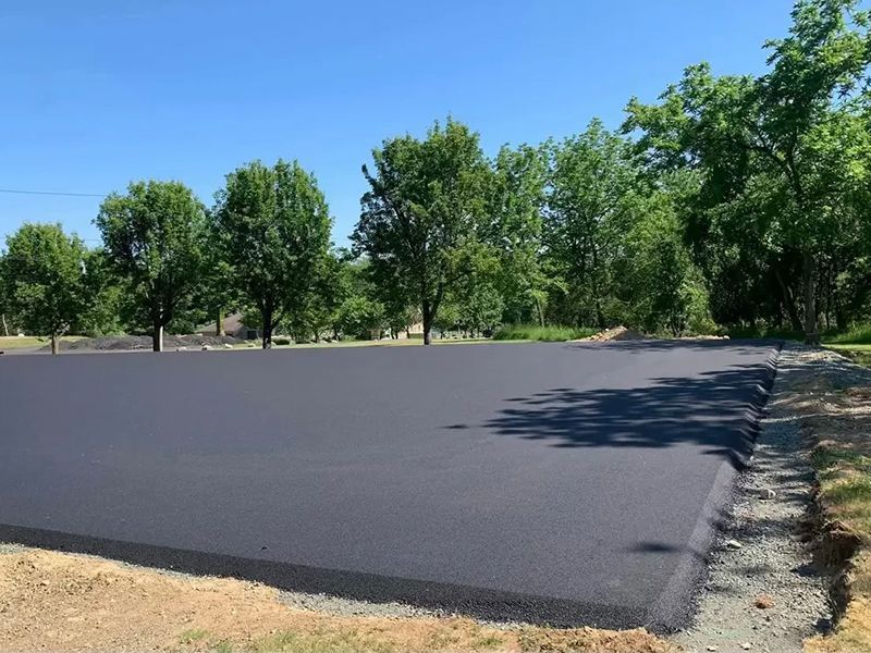 Yellow building with red roof, porch, and attached restaurant. Green lawn and a road in front.