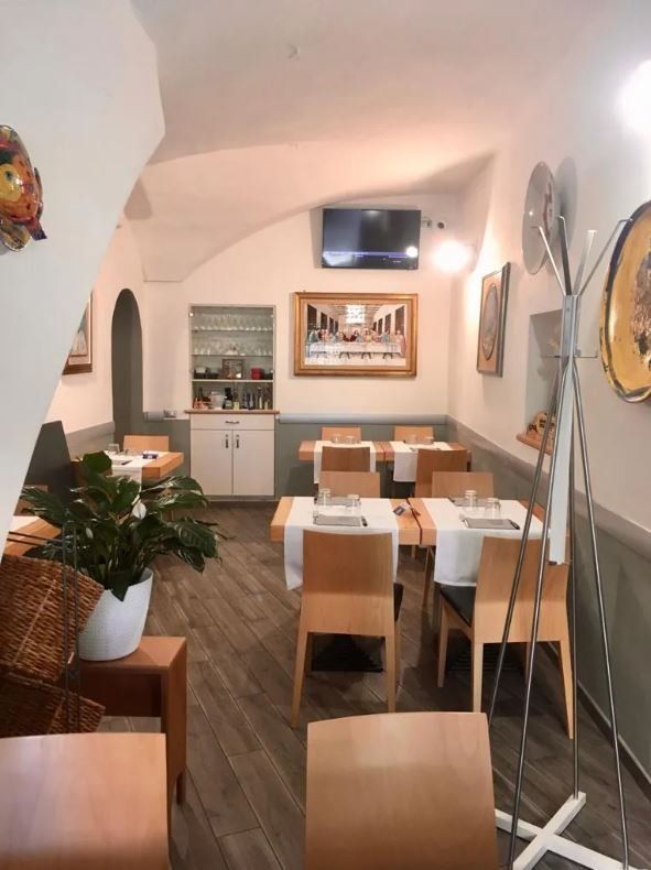 sala pizzeria con tavoli distanziati