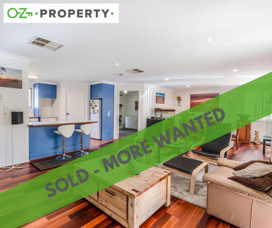 A living room with a green banner that says sold more wanted