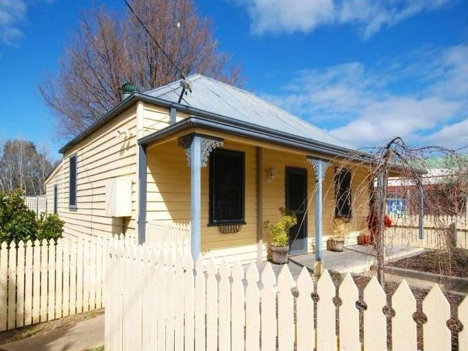 A small house with a white picket fence around it