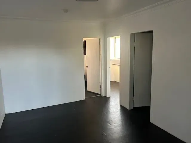 An empty room with a black floor and white walls