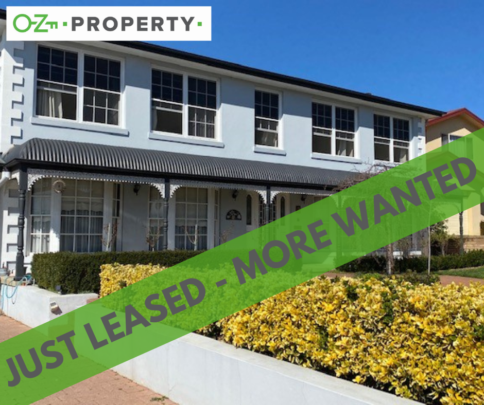 A white house with a green banner that says just leased more wanted