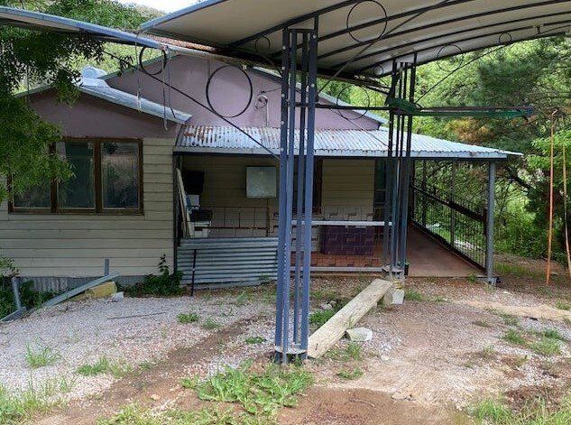 A house with a covered porch and a bench in front of it.