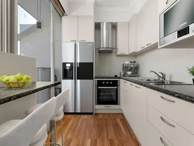 A kitchen with stainless steel appliances and white cabinets