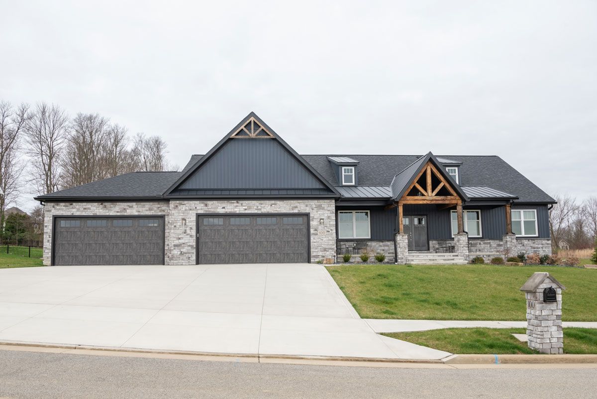 A large house with a large driveway and a mailbox in front of it.