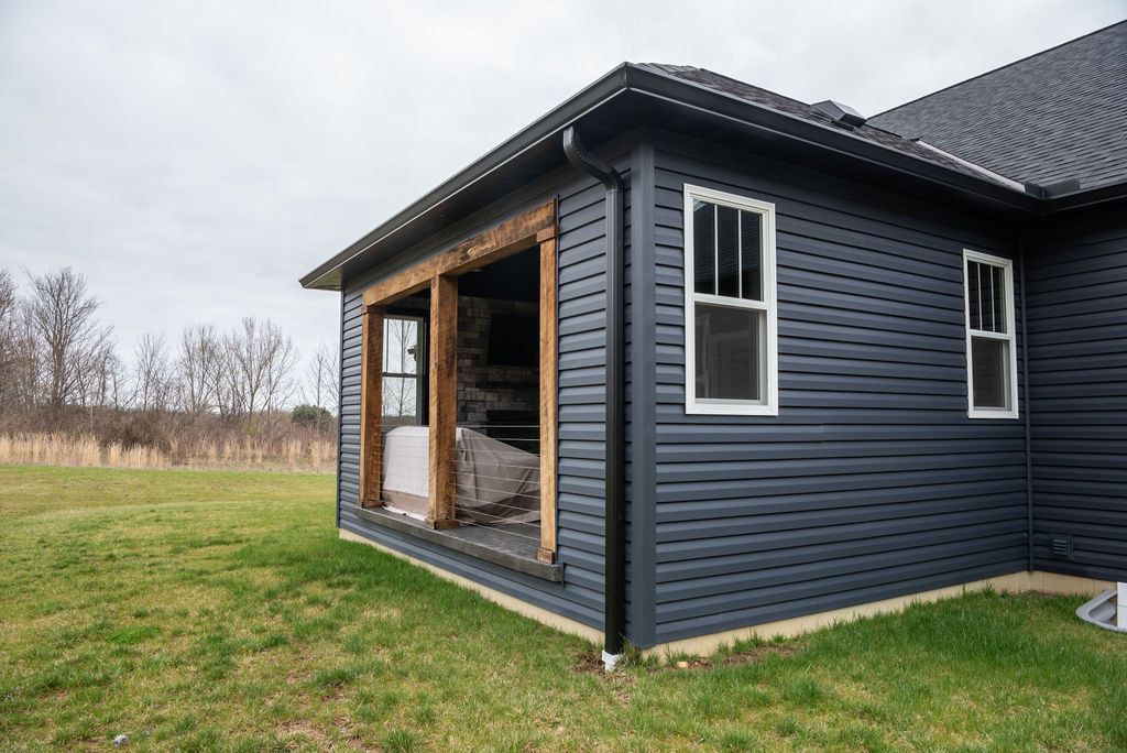 A black house with a porch and a sliding glass door.