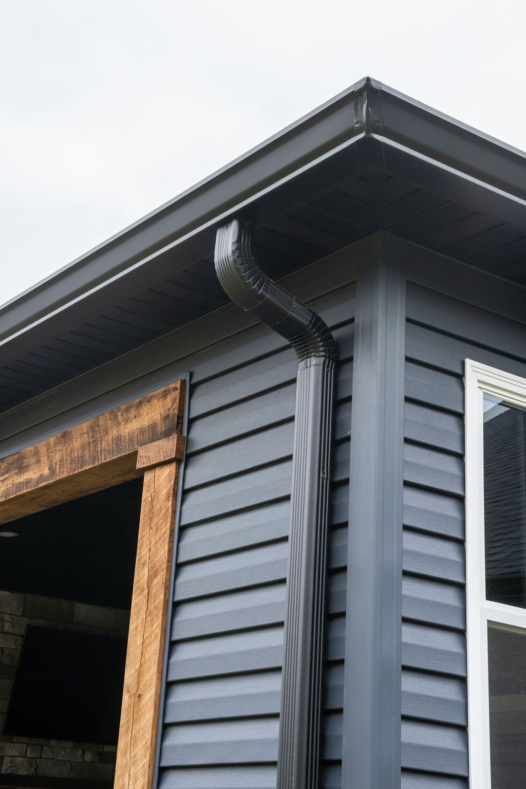 A close up of a gutter on the side of a house.