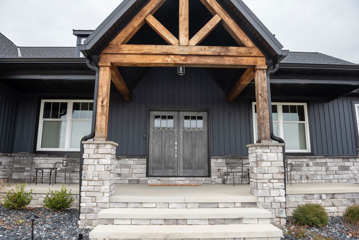 A black house with a wooden porch and stairs
